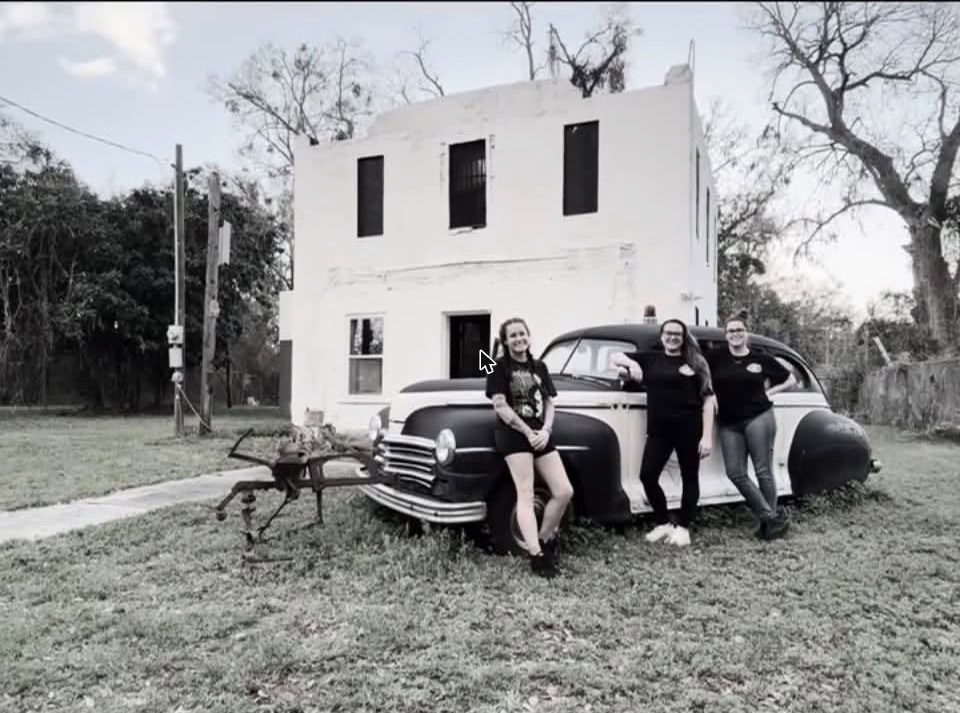 The three sisters of Trinity of Shadows pose in front of the Historic Gilchrist County Jail in Trenton, Florida
